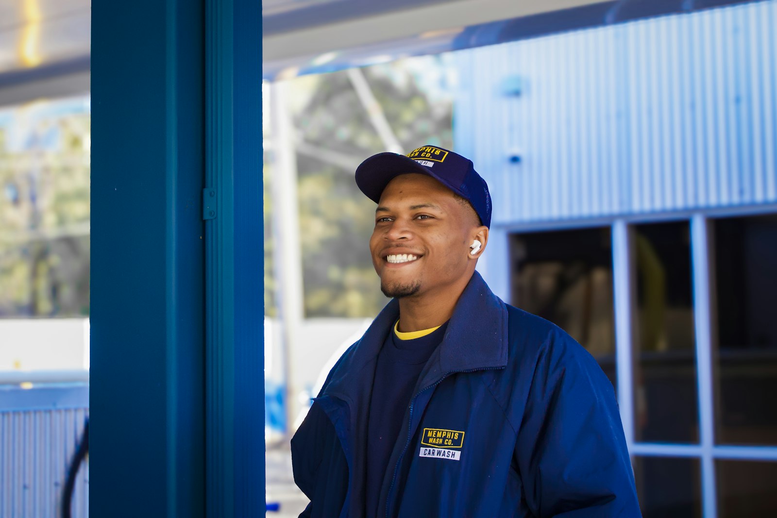 A smiling Summit Air technician in a navy company jacket and cap