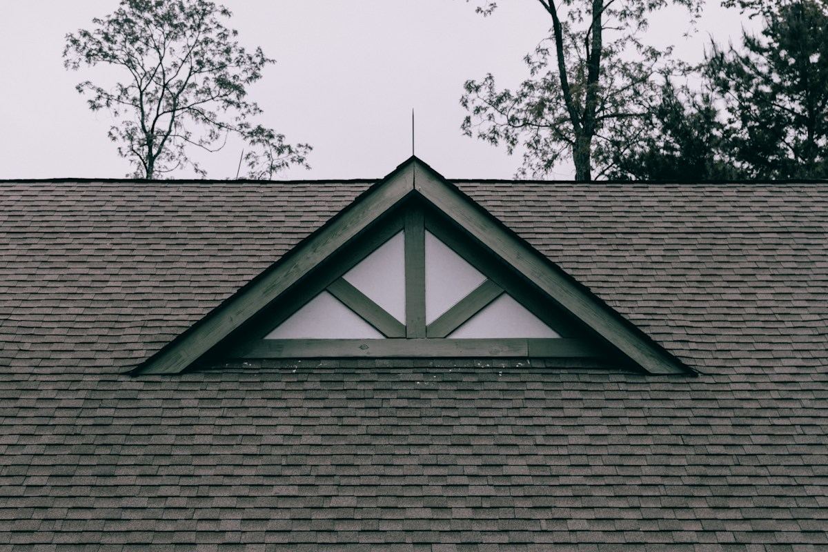 A finished dark shingle roof with a white-trimmed gable