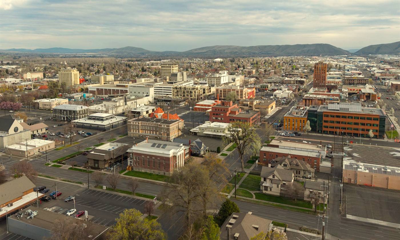 Downtown Yakima from above, with the brick buildings of the city center and the hills of the valley behind